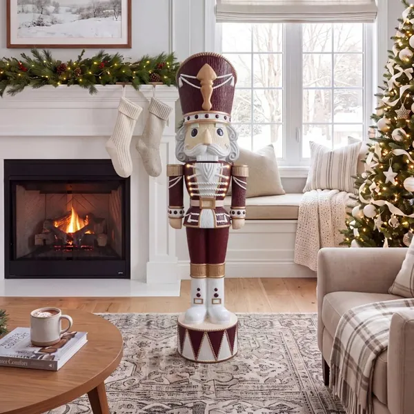 Velvet & Vanilla Otto nutcracker in burgundy and cream beside a fireplace and window seat